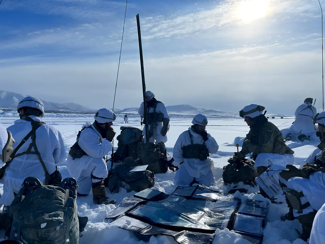 Team coordinating around equipment in snow-covered terrain