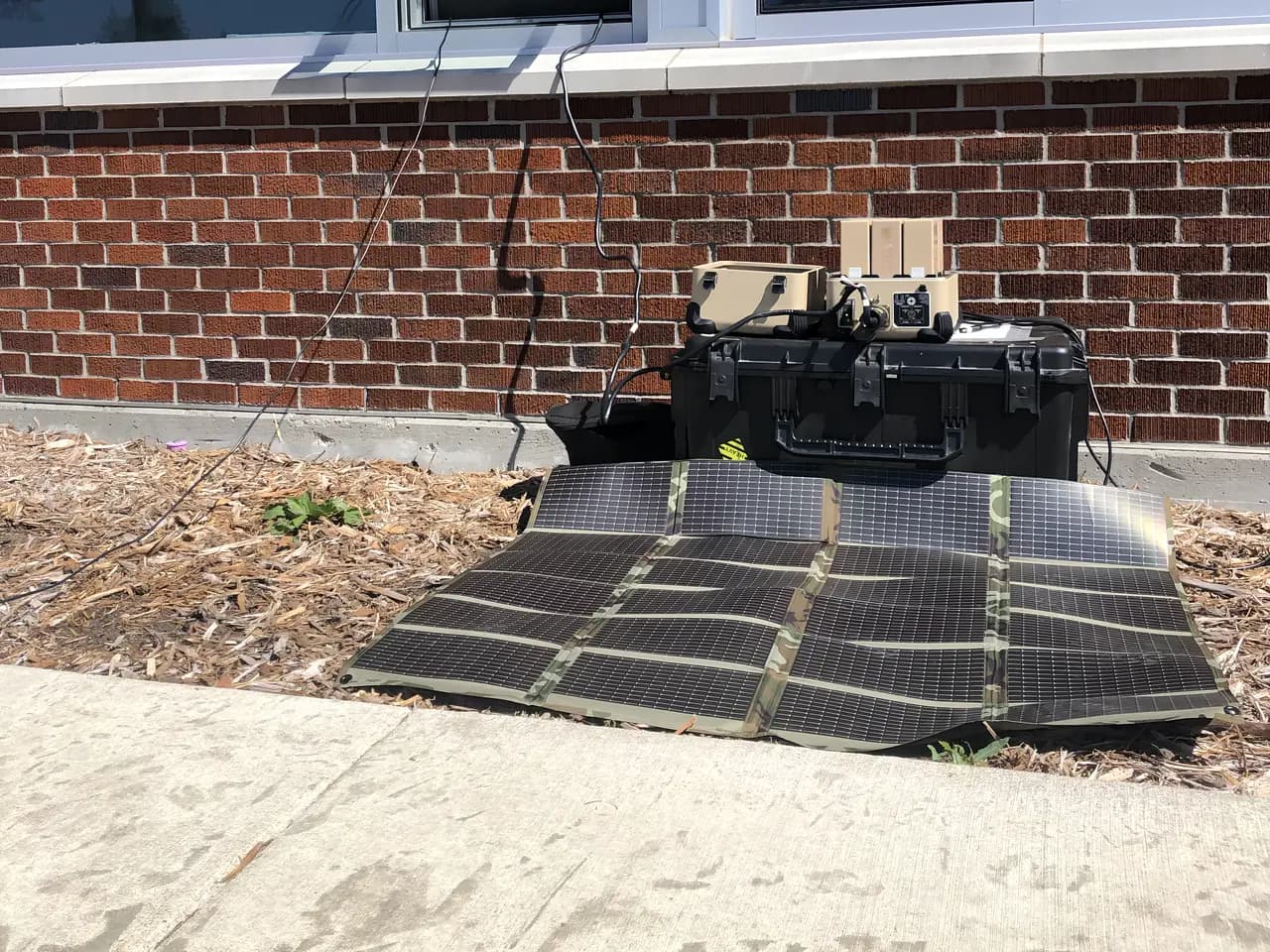 Tactical solar blanket powering equipment through a building window